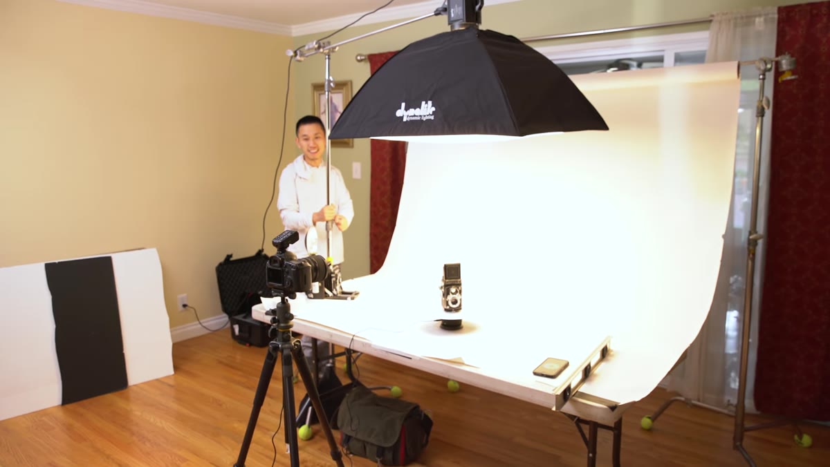Large softbox positioned above and slightly behind the product on white sweep