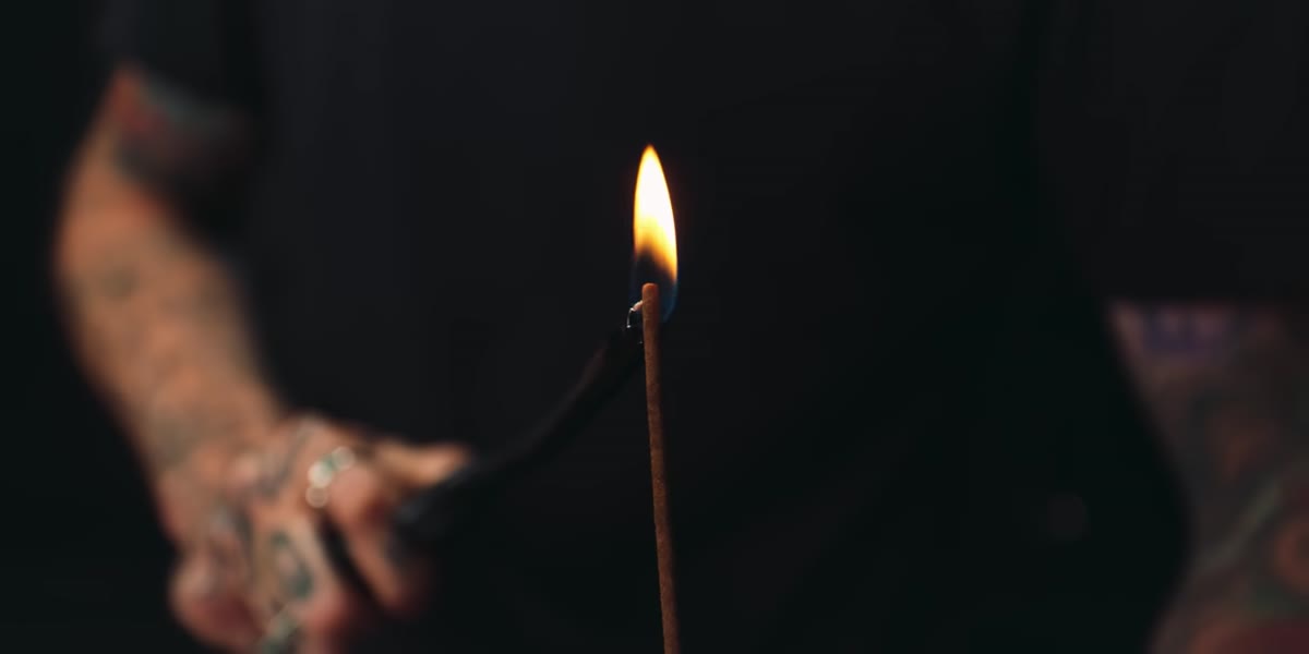 Incense stick producing continuous smoke in the background