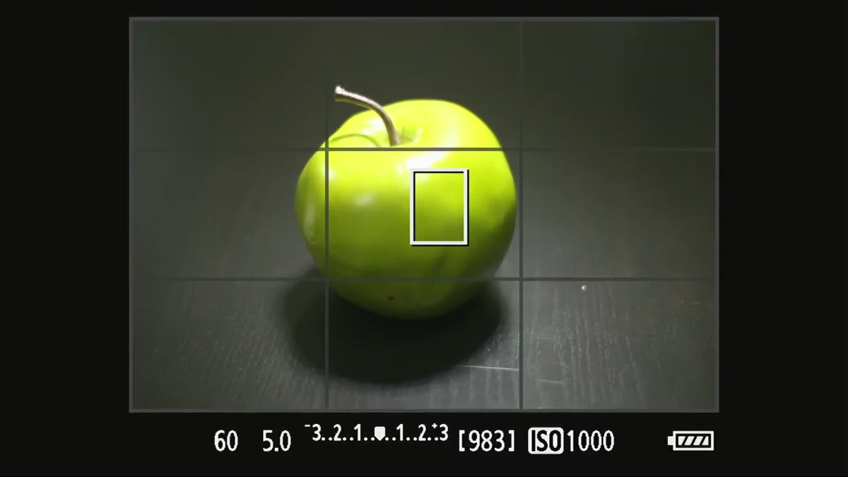 Dark reflection under the apple on the black table surface